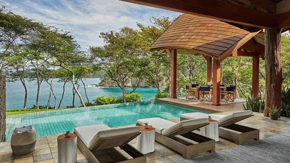 Luxurious poolside lounging area with a view of the ocean.