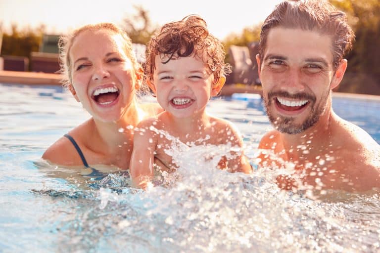 Family enjoying a sunny day in the swimming pool.